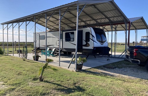 Port Bolivar House | 10 minutes walk to the beach .Covered rv spot on concrete slab. NEW CAMPER