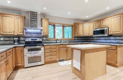 Waupaca House | A beautiful recently remodeled home nested on a wooded river lot with a hot tub.