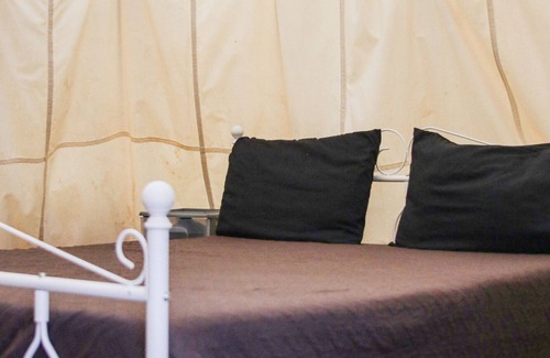 Pipe Creek RV Rental | Canvas Tipi on wooden deck overlooking a season creek.