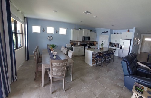 Port Malabar House | Lake view home with a screened outdoor entertainment area.