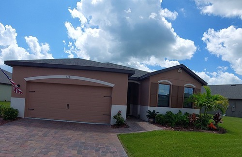 Port Malabar House | Lake view home with a screened outdoor entertainment area.