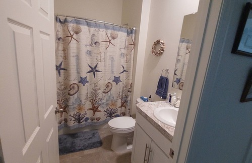 Port Malabar House | Lake view home with a screened outdoor entertainment area.