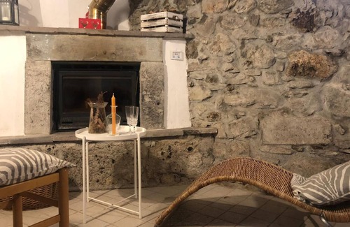 Raveo House | Rustic apartment with beams and stone.