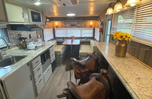 Milton RV Rental | The "Bunkhouse" (western-themed glamper) sleeps 2 to 4 avg size people. There's even a bar with real western saddles for barstools! All new electric appliances, so super-easy to "glamp" in a beautiful, treed area of the park. Access to the park's am