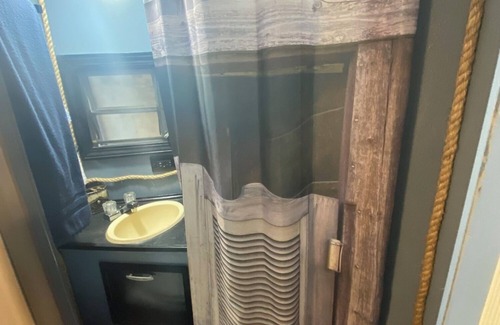 Milton RV Rental | The "Bunkhouse" (western-themed glamper) sleeps 2 to 4 avg size people. There's even a bar with real western saddles for barstools! All new electric appliances, so super-easy to "glamp" in a beautiful, treed area of the park. Access to the park's am