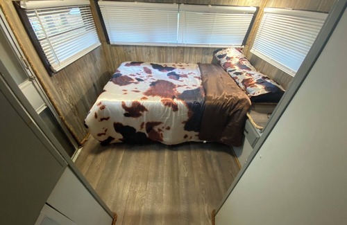 Milton RV Rental | The "Bunkhouse" (western-themed glamper) sleeps 2 to 4 avg size people. There's even a bar with real western saddles for barstools! All new electric appliances, so super-easy to "glamp" in a beautiful, treed area of the park. Access to the park's am