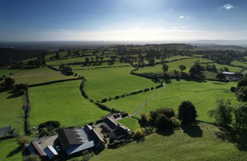 Oswestry House | The Granary at Pentregaer Ucha, tennis court & lake.