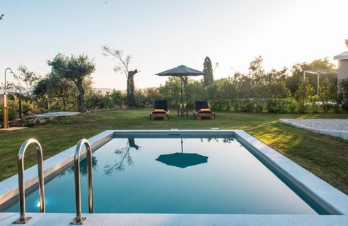 Doukades Villa | The villa's large private garden leads directly to the outdoor private pool.