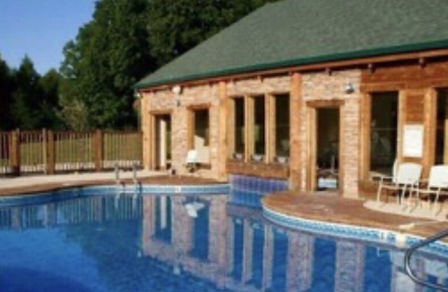 Cozy cabin with fire pit, hot tub, and pool, and a swing set in the backyard!