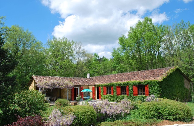Large stone house between forest and fields with swimming pool