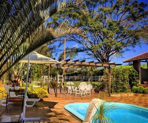 Sítio com piscina cercada por belas paisagens