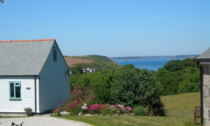Helford Passage Cottage | Nanteague - quirky luxury chalet-style cottage, sea views across a wooded valley