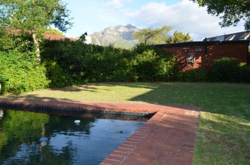 Die Boord House | Retro Red Stone Villa with pool & lush garden