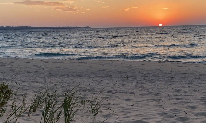 Maple City Condo | Riverfront condo with Lake Michigan beach access, fireplace and deck.