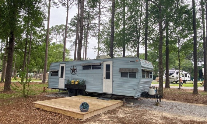Milton RV Rental | The "Bunkhouse" (western-themed glamper) sleeps 2 to 4 avg size people. There's even a bar with real western saddles for barstools! All new electric appliances, so super-easy to "glamp" in a beautiful, treed area of the park. Access to the park's am